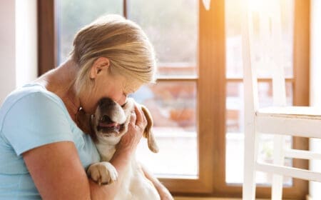 An older woman is comforted by her emotional support dog.