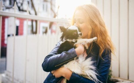 woman holding small dog outside
