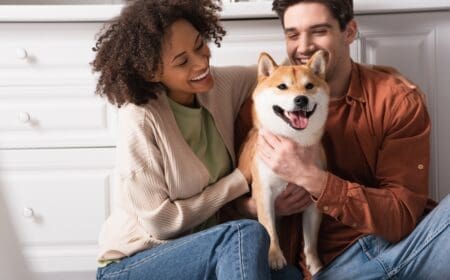 man and woman hugging a dog