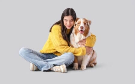 girl hugging australian shepherd dog