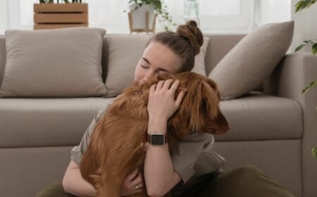Woman hugging dog emotional support animal at home.