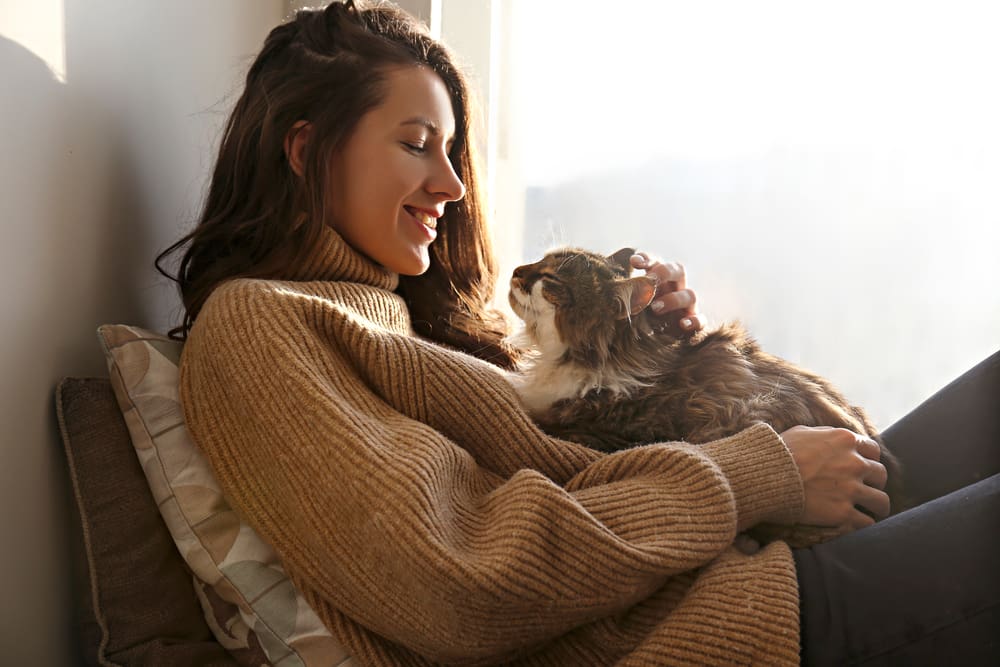 woman holding happy cat on her lap