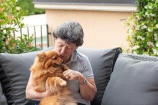 elderly woman holding small dog