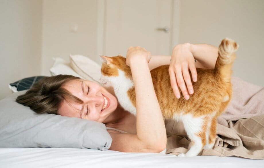 woman smiling cuddling cat