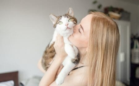 woman kissing cat