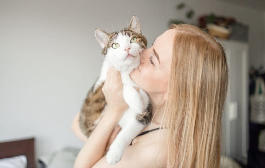 woman kissing cat