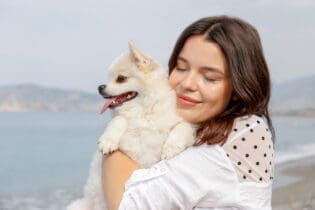 young woman hugging pomeranian spitz