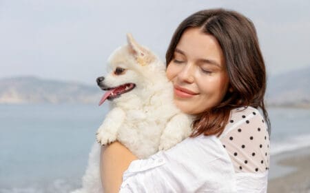 young woman hugging pomeranian spitz