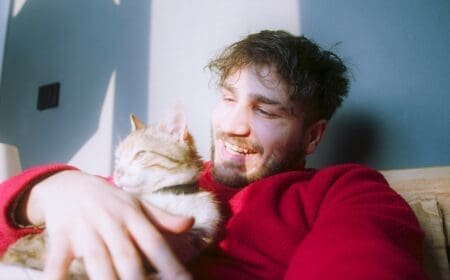 A man cuddling with a cat emotional support animal.