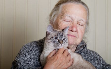 senior woman with therapy cat cuddling
