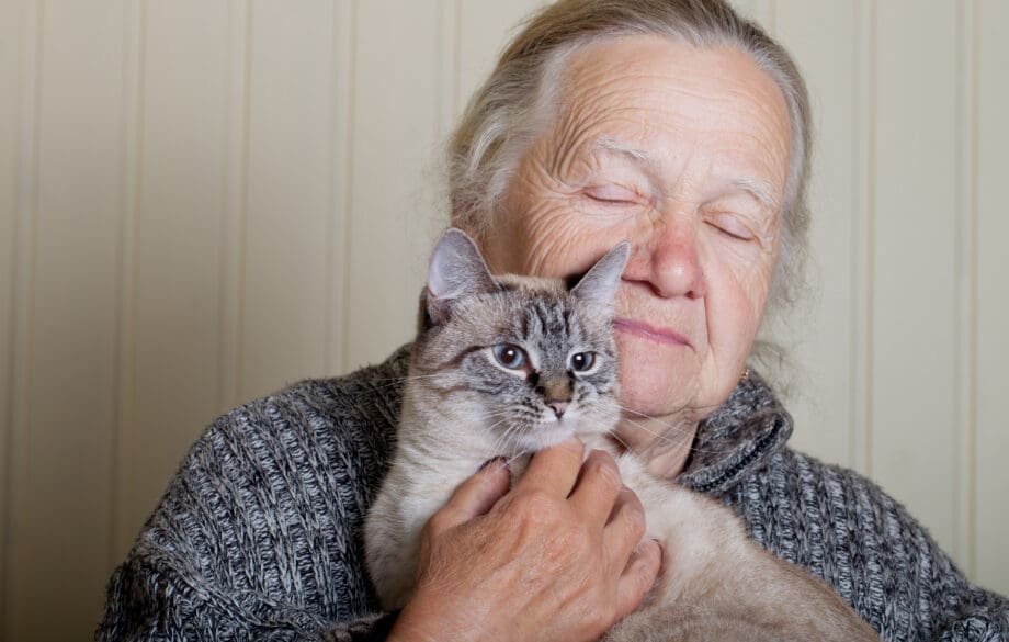 senior woman with therapy cat cuddling